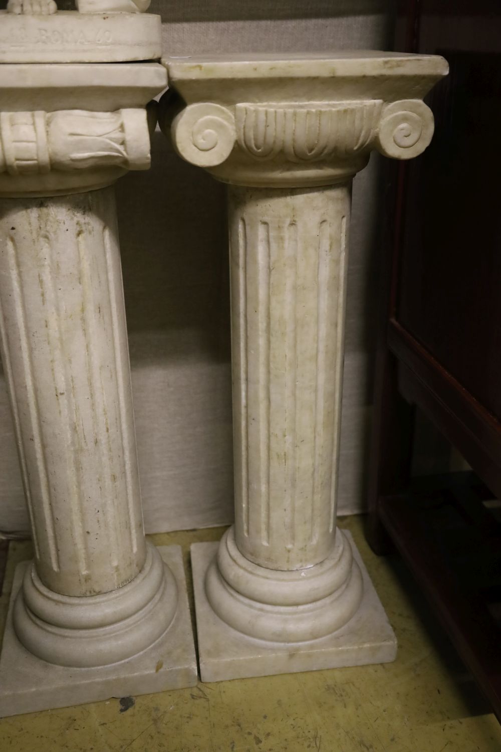 A pair of marble ionic columns together with a marble carving signed Esule, figure 70cm high